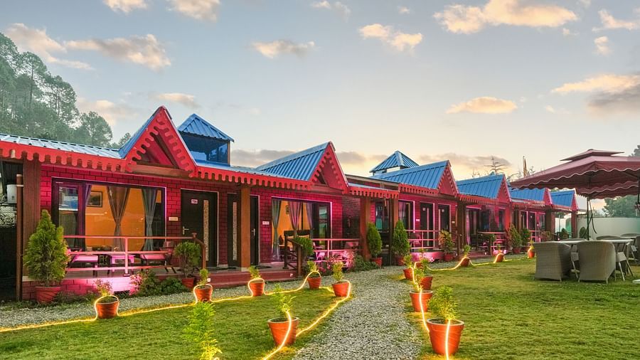 Sol Glow Resort, Nainital Nainital A view of some cottages placed adjacently, with pots paving way on the walking path, decorated with LED lights